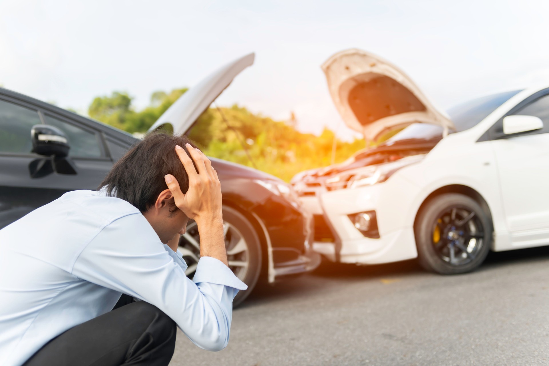 young woman with smartphone by the damaged car after a car accident, making a phone call and for insurance agent to quick attention